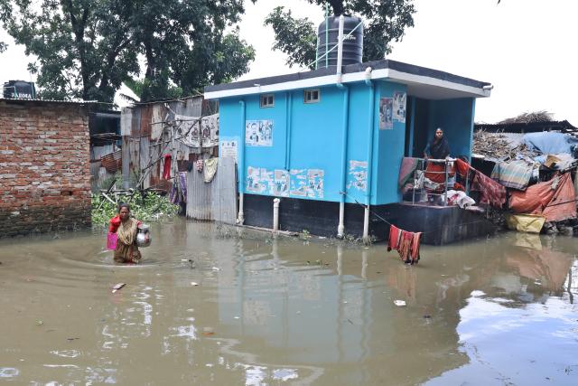 (260715) -- DHAKA, July 15, 2026 (Xinhua) -- A woman wades through floods inflicted by heavy rainfall in Dhaka, Bangladesh, on July 14, 2026. (Photo by Habibur Rahman/Xinhua)