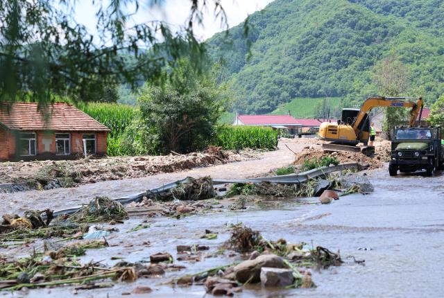 (260715) -- KAIYUAN, July 15, 2026 (Xinhua) -- Staff members clear a road in Zengjiazhai Village of Kaiyuan City, northeast China's Liaoning Province, July 15, 2026. On Tuesday, China's national commission for disaster prevention, reduction and relief activated a Level-IV national disaster relief emergency response for Liaoning Province, which was hit by rainstorms and flooding.
   China has a four-tier emergency response system, with Level I being the most severe. (Xinhua/Han He)
