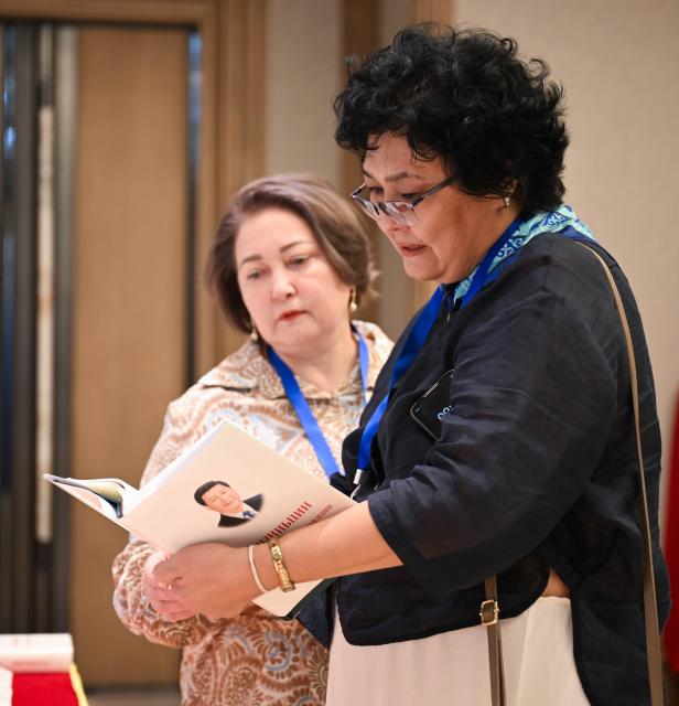 (260715) -- ASTANA, July 15, 2026 (Xinhua) -- Guests read a copy of "Xi Jinping: The Governance of China" at an event promoting the fifth volume of the book in Astana, Kazakhstan, July 15, 2026. The event was held here on Wednesday. (Xinhua/Li Renzi)