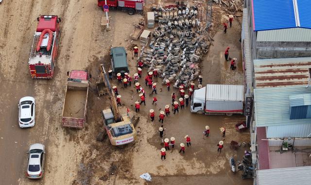(260715) -- NANNING, July 15, 2026 (Xinhua) -- An aerial drone photo taken on July 14, 2026 shows people clearing a street in Yunbiao Town of Hengzhou City, Nanning City of south China's Guangxi Zhuang Autonomous Region. Efforts are underway to facilitate flood relief and recovery in Guangxi, which has been hit by severe rainstorms and flooding caused by Typhoon Maysak. (Xinhua/Huang Xiaobang)