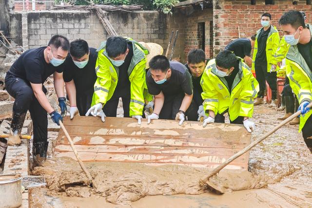 (260715) -- NANNING, July 15, 2026 (Xinhua) -- Rescuers remove sludge in Yunbiao Town of Hengzhou City, Nanning City of south China's Guangxi Zhuang Autonomous Region, July 15, 2026. Efforts are underway to facilitate flood relief and recovery in Guangxi, which has been hit by severe rainstorms and flooding caused by Typhoon Maysak. (Photo by Li Yonghua/Xinhua)