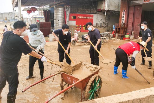 (260715) -- NANNING, July 15, 2026 (Xinhua) -- Rescuers remove sludge in Yunbiao Town of Hengzhou City, Nanning City of south China's Guangxi Zhuang Autonomous Region, July 15, 2026. Efforts are underway to facilitate flood relief and recovery in Guangxi, which has been hit by severe rainstorms and flooding caused by Typhoon Maysak. (Photo by Li Yonghua/Xinhua)