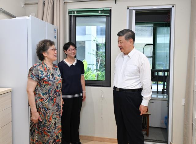 (260715) -- SHANGHAI, July 15, 2026 (Xinhua) -- Chinese President Xi Jinping, also general secretary of the Communist Party of China (CPC) Central Committee and chairman of the Central Military Commission, looks closely at the living conditions at the home of a resident in Huangpu District, Shanghai, east China, July 15, 2026. Xi made an inspection trip to Shanghai on Wednesday. (Xinhua/Yan Yan)