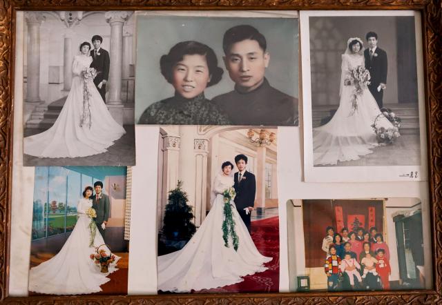 (260715) -- SHANGHAI, July 15, 2026 (Xinhua) -- This photo taken on July 14, 2026 shows a collection of photos of Yu Meixiang's family. In Shanghai's Pengpu Xincun, one of the city's earliest newly built residential areas for in-service staff, senior residents like 92-year-old Yu Meixiang and 75-year-old Peng Juhua shared their memories of bygone days at a gathering with children of the neighborhood. Their stories reflect not only personal history but also a remarkable urban renewal that has transformed their lives while keeping their community intact.
   Built mostly in the 1950s and 1960s, the residential buildings in Pengpu Xincun had long fallen into disrepair, as could be seen in the leaky roofs and crumbling walls. The daily hardships had been worsened by kitchens and bathrooms shared among neighbors, especially when families there were growing in sizes. 
   In response, the local government launched a renewal project in 2005. Residents temporarily relocated while their old homes were reconstructed on the original plots. After two decades of work in multiple phases, Pengyi residential compound of Pengpu Xincun officially opened for its earlier residents to move back in June 2025.
   The refurbished apartments there are now more spacious, each with a private kitchen and bathroom. Elevators, barrier-free access, and a pedestrian-friendly internal traffic system are now in place to make life much easier for the elderly. A neighborhood cultural center with a library and gym is set to open soon. (Xinhua/Fang Zhe)
