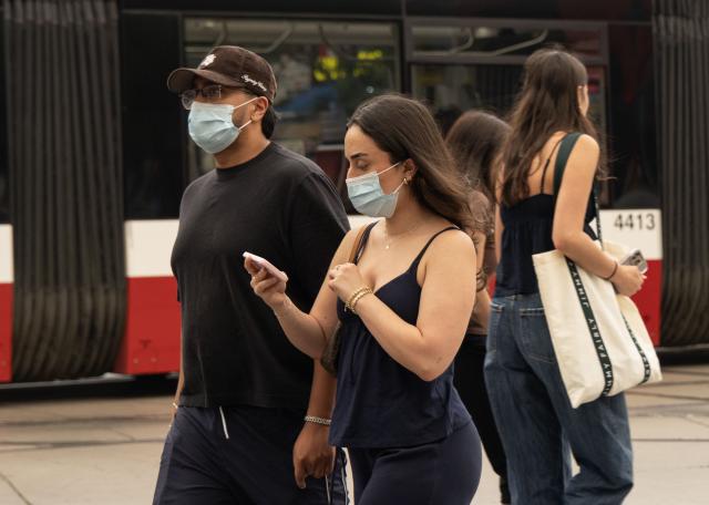 (260715) -- TORONTO, July 15, 2026 (Xinhua) -- People wearing face masks walk on the street as wildfire smoke from northwestern Ontario fills the sky in Toronto, Canada, on July 15, 2026. Wildfires sweeping across northwestern Ontario, Canada, in recent days have caused severe smog and a sharp deterioration in air quality in several regions, including Ottawa, the nation's capital, and Toronto, Canada's largest city. (Photo by Zou Zheng/Xinhua)