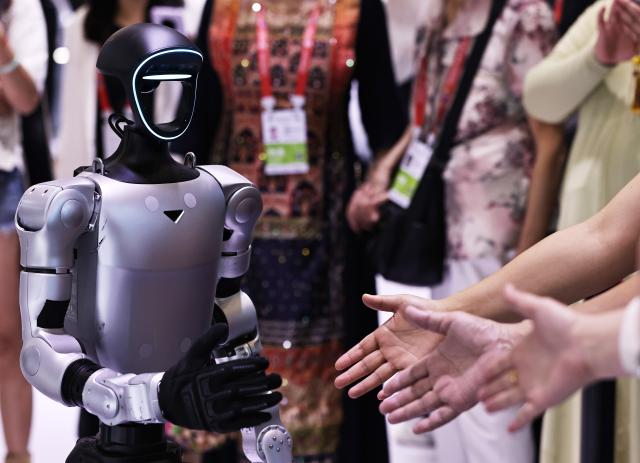 (260718) -- HANGZHOU, July 18, 2026 (Xinhua) -- Visitors interact with a robot from Unitree Robotics during the sixth China International Consumer Products Expo (CICPE) in Haikou, south China's Hainan Province, April 14, 2026. (Xinhua/Gao Jing)