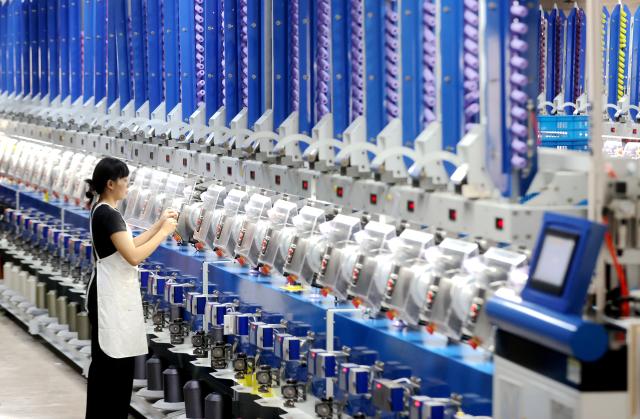 (260718) -- HANGZHOU, July 18, 2026 (Xinhua) -- A worker checks automatic spool winders at a smart factory of a company in Xin'an Town of Deqing County, Huzhou City of east China's Zhejiang Province, June 15, 2026. (Photo by Xie Shangguo/Xinhua)