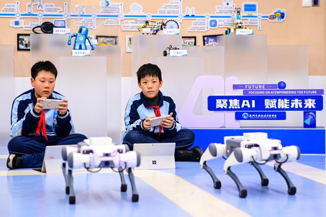 (260718) -- HANGZHOU, July 18, 2026 (Xinhua) -- Students of Hangzhou Baochu Pagoda Experimental School learn to program robotic dogs during an AI course in Hangzhou, east China's Zhejiang Province, Dec. 2, 2025. (Xinhua/Jiang Han)