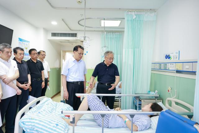 (260718) -- CHONGQING, July 18, 2026 (Xinhua) -- Chinese Vice Premier Zhang Guoqing, also a member of the Political Bureau of the Communist Party of China (CPC) Central Committee, visits injured people at the county people's hospital in Pengshui Miao and Tujia Autonomous County, southwest China's Chongqing Municipality, July 18, 2026. Zhang led officials from relevant departments to Pengshui Miao and Tujia Autonomous County in Chongqing on Friday evening to direct on-site search and rescue operations and emergency response work on behalf of the CPC Central Committee and the State Council. (Xinhua/Liu Bin)
