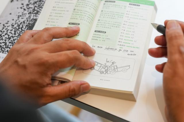 (260718) -- CHENGDU, July 18, 2026 (Xinhua) -- Yuan Xilin studies Spanish at a café in Chengdu, southwest China's Sichuan Province, July 15, 2026. At 34, Yuan Xilin works as a ticket attendant at a Sichuan Opera theater in Chengdu, where he checks tickets, welcomes visitors and helps audiences find their way into the theater.
As Chengdu attracts growing numbers of international visitors interested in traditional Chinese opera and Sichuan Opera, Yuan meets dozens of overseas tourists every day. Hoping to make them feel more at ease, he began learning simple greetings in different languages so he could welcome them in their native tongue.
Yuan's interest in languages began in high school, when he came across a booklet introducing several foreign languages. Drawn to the rhythm of Spanish music and the sound of classical guitar, he developed a particular interest in Spanish.
As China's visa-free transit and other travel facilitation policies have brought more international visitors to the country, Yuan has expanded his language skills from English and Spanish to Italian, French, Portuguese, Russian, Polish and more. What once began with a simple greeting has gradually grown into brief conversations about visitors' experiences in China and introductions to Chengdu's local culture.
For Yuan, language is a bridge between cultures. He believes that even a simple greeting in a visitor's native language can make them feel welcome while creating opportunities for cultural exchange and his own personal growth. (Xinhua/Wang Xi)