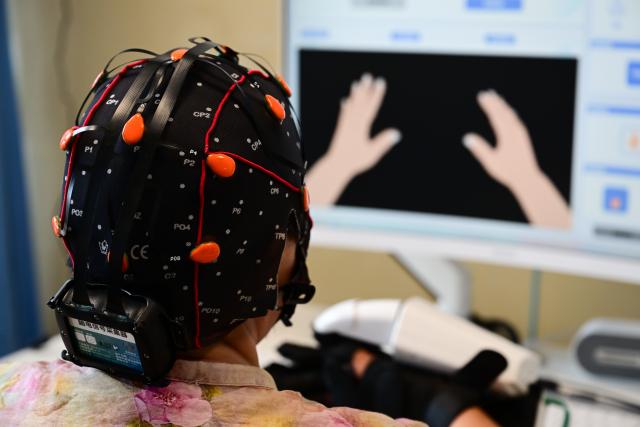 (260718) -- BENGBU, July 18, 2026 (Xinhua) -- A patient uses a brain-computer interface (BCI) device for hand rehabilitation at a hospital in Bengbu, east China's Anhui Province, July 17, 2026. Bengbu, a traditional industrial city, has stepped up the development of its brain-computer interface (BCI) industry in recent years. By strengthening collaboration among industry, research institutes and medical institutions, Bengbu has built an innovation ecosystem that supports both BCI research and clinical application, aiming to become an emerging BCI innovation hub in the Yangtze River Delta region. (Xinhua/Zhou Mu)
