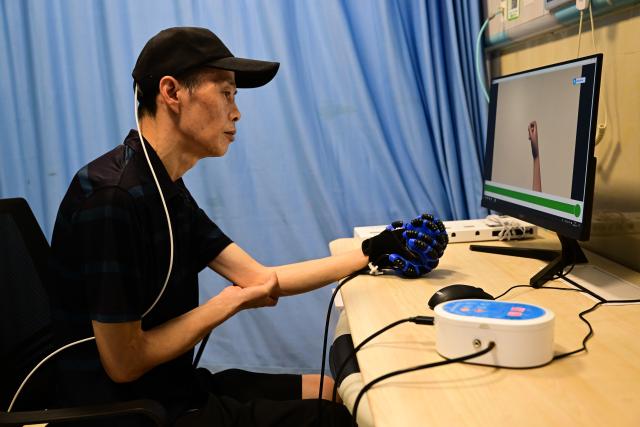 (260718) -- BENGBU, July 18, 2026 (Xinhua) -- A patient, who received Anhui's first semi-invasive brain-computer interface (BCI) surgery in April 2026, undergoes rehabilitation training at a hospital in Bengbu, east China's Anhui Province, July 17, 2026. Bengbu, a traditional industrial city, has stepped up the development of its brain-computer interface (BCI) industry in recent years. By strengthening collaboration among industry, research institutes and medical institutions, Bengbu has built an innovation ecosystem that supports both BCI research and clinical application, aiming to become an emerging BCI innovation hub in the Yangtze River Delta region. (Xinhua/Zhou Mu)