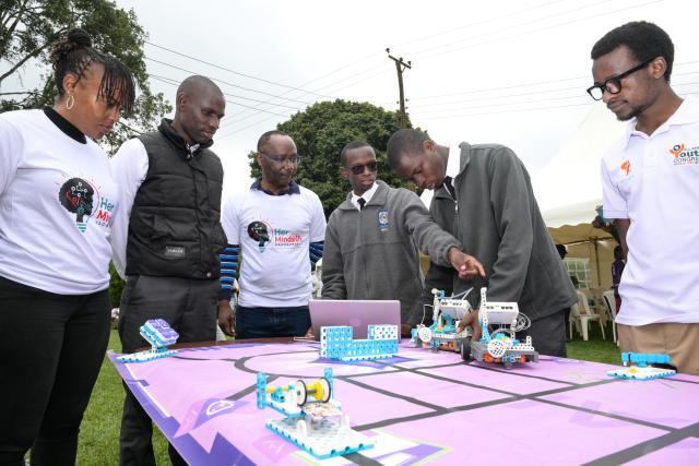 (260718) -- NAIROBI, July 18, 2026 (Xinhua) -- Students (2nd R and 3rd R) explain robot coding to people during an artificial intelligence (AI)-enabled coding and robotics competition in Kiambu county, central Kenya, July 17, 2026. More than 200 young learners participated in the competition here on Friday.
   TO GO WITH "Kenya launches AI-powered coding competition for schoolchildren" (Xinhua/Yang Guang)