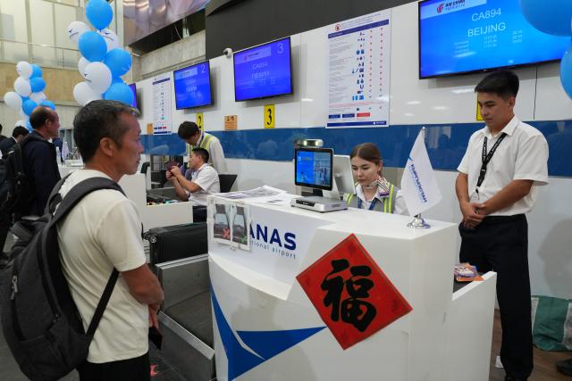 (260718) -- BISHKEK, July 18, 2026 (Xinhua) -- Passengers of flight CA894 check in at the Manas International Airport in Bishkek, Kyrgyzstan, July 17, 2026. Air China's inaugural direct flight between the capitals of China and Kyrgyzstan officially launched on Friday after flight CA893, departing from Beijing Capital International Airport, successfully landed at Manas International Airport in Bishkek.
   According to Air China, regular flights in both directions of the new air service operate three times a week, namely on Mondays, Fridays, and Sundays. Flight CA893 departs from Beijing and travels to Bishkek, with a flight time of five hours 40 minutes; flight CA894 departs from Bishkek and travels to Beijing, with a flight time of four hours 50 minutes. (Xinhua/Jiang Youlin)