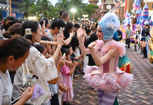 (260718) -- HAIKOU, July 18, 2026 (Xinhua) -- A performer interacts with audiences during a carnival parade in Haikou, south China's Hainan Province, July 18, 2026. The 2026 Hainan Island Carnival opened here on Saturday and will last until Aug. 18, during which over 50 special events will be held. (Xinhua/Guo Cheng)