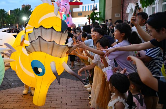 (260718) -- HAIKOU, July 18, 2026 (Xinhua) -- A performer interacts with audiences during a carnival parade in Haikou, south China's Hainan Province, July 18, 2026. The 2026 Hainan Island Carnival opened here on Saturday and will last until Aug. 18, during which over 50 special events will be held. (Xinhua/Guo Cheng)