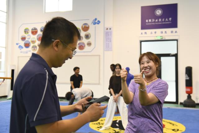 (260719) -- JINAN, July 19, 2026 (Xinhua) -- Zeela Nebulani (R) gives a thumb-up to her teacher Li Ning at Rizhao Polytechnic University in Rizhao, east China's Shandong Province, July 16, 2026. Zeela Nebulani and Zoura Nebulani are sisters from Indonesia with ancestral roots in southeast China's Fujian Province. Growing up in a martial arts family, with both of their parents working as professional martial arts coaches, Zeela started martial arts training at the age of 6 and began practicing Tai Chi at 12. 
  In September 2024, Zeela enrolled at Rizhao Polytechnic University in east China's Shandong Province, where she majors in international trade. Inspired by her sister, Zoura enrolled at the same university this year and chose the same major.
   While studying at the university, the sisters not only focus on their academic studies, but also continue their daily martial arts training. In their spare time, they participate in campus cultural performances and exchange activities with young people from China and other countries. They also create bilingual short videos featuring Rizhao's coastal scenery, local folk traditions and daily life, sharing them on Indonesian social media platforms. They introduce Indonesian culture to their teachers and classmates, promoting cultural exchanges between China and Indonesia.
   Zeela and Zoura hope to serve as a cultural bridge between young people in China and Indonesia and contribute to closer friendship between the two countries. (Xinhua/Guo Xulei)
