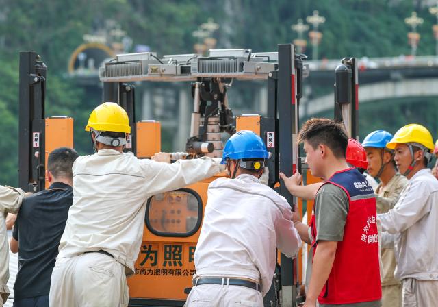 (260719) -- CHONGQING, July 19, 2026 (Xinhua) -- Volunteers assist in moving an electric lighting equipment at the site of a mountain collapse in Pengshui Miao and Tujia Autonomous County of Chongqing, southwest China, July 17, 2026. A rainfall-induced mountain collapse occurred at 9:08 a.m. on Friday in the Hanjia sub-district of Pengshui, burying more than 10 residential buildings, while leaving some local residents trapped and unaccounted for. 
  China activated a Level-II national emergency response for geological disasters. Multiple rescue forces including emergency response, fire control and public security rushed to the scene and launched full-scale search and rescue operations, while local residents also volunteered to take part in the rescue efforts. (Xinhua/Huang Wei)