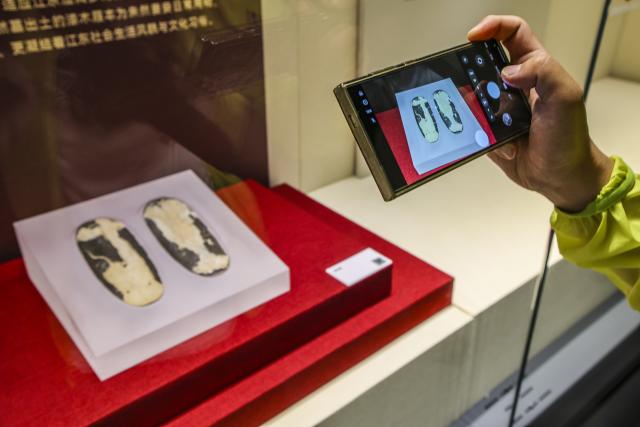 (260719) -- MAANSHAN, July 19, 2026 (Xinhua) -- A visitor takes photos at an exhibition on lacquered wooden treasures at the Three Kingdoms Zhu Ran Family Cemetery Museum in Maanshan, east China's Anhui Province, July 18, 2026.
  The museum currently exhibits rare lacquered wooden treasures unearthed from the tomb of general Zhu Ran in the Eastern Wu Kingdom during the Three Kingdoms period (220-280). Among these masterpieces, lacquered wooden clogs are displayed to the public for the first time since they were excavated more than 40 years ago. (Photo by Wang Wensheng/Xinhua)