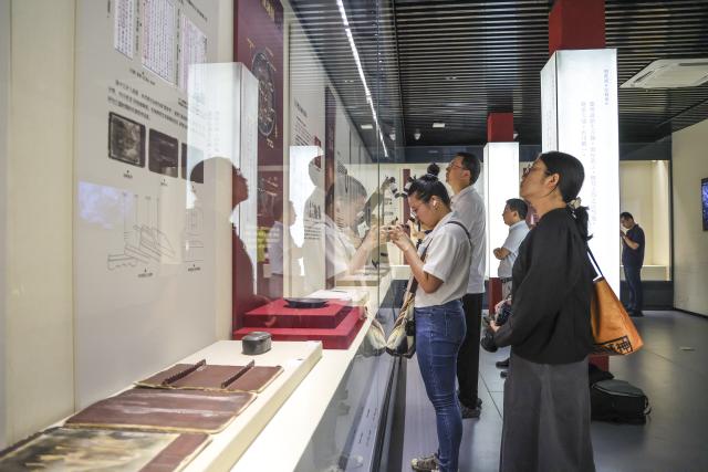 (260719) -- MAANSHAN, July 19, 2026 (Xinhua) -- People visit an exhibition on lacquered wooden treasures at the Three Kingdoms Zhu Ran Family Cemetery Museum in Maanshan, east China's Anhui Province, July 18, 2026.
  The museum currently exhibits rare lacquered wooden treasures unearthed from the tomb of general Zhu Ran in the Eastern Wu Kingdom during the Three Kingdoms period (220-280). Among these masterpieces, lacquered wooden clogs are displayed to the public for the first time since they were excavated more than 40 years ago. (Photo by Wang Wensheng/Xinhua)