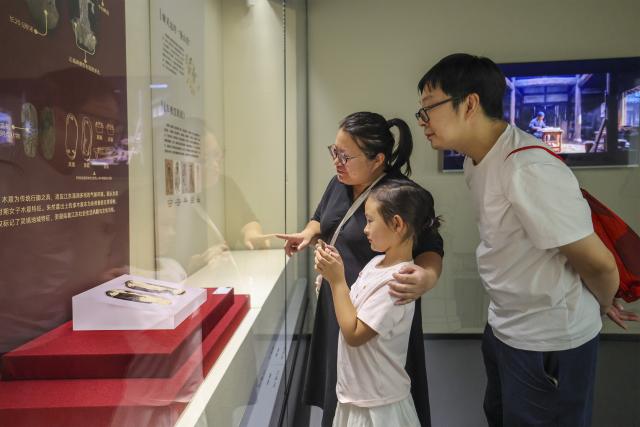 (260719) -- MAANSHAN, July 19, 2026 (Xinhua) -- People visit an exhibition on lacquered wooden treasures at the Three Kingdoms Zhu Ran Family Cemetery Museum in Maanshan, east China's Anhui Province, July 18, 2026.
  The museum currently exhibits rare lacquered wooden treasures unearthed from the tomb of general Zhu Ran in the Eastern Wu Kingdom during the Three Kingdoms period (220-280). Among these masterpieces, lacquered wooden clogs are displayed to the public for the first time since they were excavated more than 40 years ago. (Photo by Wang Wensheng/Xinhua)