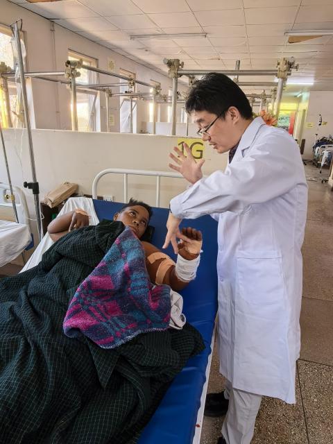 (260719) -- MBEYA, July 19, 2026 (Xinhua) -- This photo taken with a mobile phone shows Chinese spine surgeon Zhou Chao (R) checking a patient at Mbeya Zonal Referral Hospital in Mbeya, Tanzania, May 4, 2026. TO GO WITH "Feature: Chinese doctors bring hope to Tanzanian mother after pioneering spine surgery" (The 28th Chinese medical team in Tanzania/Handout via Xinhua)