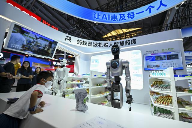 (260719) -- SHANGHAI, July 19, 2026 (Xinhua) -- A visitor watches an intelligent robot pharmacy during the 2026 World AI Conference and High-Level Meeting on Global AI Governance in Shanghai, east China, July 19, 2026. The event scheduled from Friday to Monday showcases exhibitions of a number of AI agent hardware and system products, highlighting the transition of next-generation AI from a tool to an intelligent partner, empowering various industries and everyday life. (Xinhua/Chen Haoming)