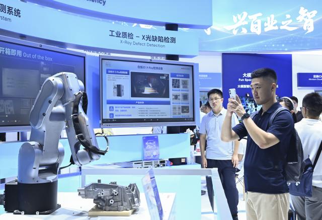 (260719) -- SHANGHAI, July 19, 2026 (Xinhua) -- A visitor takes photos of a robot during the 2026 World AI Conference and High-Level Meeting on Global AI Governance in Shanghai, east China, July 19, 2026. The event scheduled from Friday to Monday showcases exhibitions of a number of AI agent hardware and system products, highlighting the transition of next-generation AI from a tool to an intelligent partner, empowering various industries and everyday life. (Xinhua/Chen Haoming)