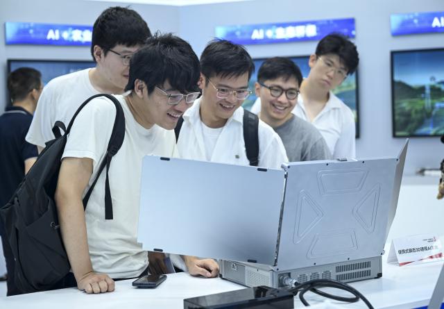 (260719) -- SHANGHAI, July 19, 2026 (Xinhua) -- Visitors observe a portable transient 3D modeling AI system during the 2026 World AI Conference and High-Level Meeting on Global AI Governance in Shanghai, east China, July 19, 2026. The event scheduled from Friday to Monday showcases exhibitions of a number of AI agent hardware and system products, highlighting the transition of next-generation AI from a tool to an intelligent partner, empowering various industries and everyday life. (Xinhua/Chen Haoming)
