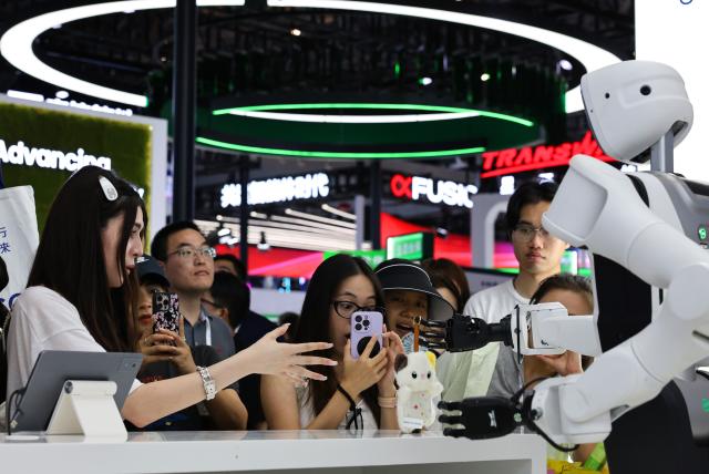 (260719) -- SHANGHAI, July 19, 2026 (Xinhua) -- Visitors experience services provided by a robot during the 2026 World AI Conference and High-Level Meeting on Global AI Governance in Shanghai, east China, July 19, 2026. The event scheduled from Friday to Monday showcases exhibitions of a number of AI agent hardware and system products, highlighting the transition of next-generation AI from a tool to an intelligent partner, empowering various industries and everyday life. (Xinhua/Fang Zhe)