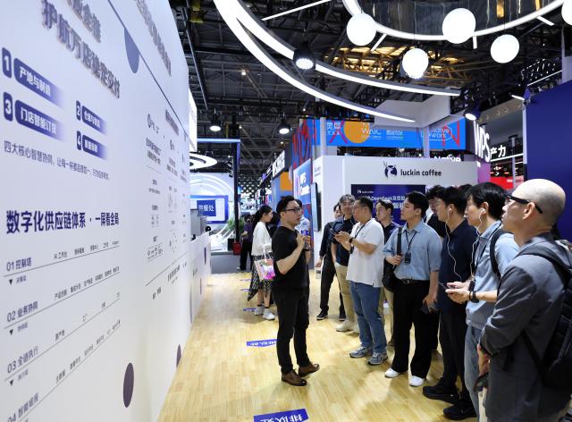 (260719) -- SHANGHAI, July 19, 2026 (Xinhua) -- Visitors learn about the digital intelligence management across the entire industry chain at the booth of Luckin Coffee during the 2026 World AI Conference and High-Level Meeting on Global AI Governance in Shanghai, east China, July 19, 2026. The event scheduled from Friday to Monday showcases exhibitions of a number of AI agent hardware and system products, highlighting the transition of next-generation AI from a tool to an intelligent partner, empowering various industries and everyday life. (Xinhua/Liu Ying)