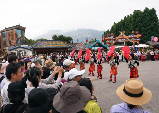 (260719) -- KUNMING, July 19, 2026 (Xinhua) -- Tourists watch a dance performance at a scenic area in Kunming City, southwest China's Yunnan Province, July 18, 2026. (Photo by Liang Zhiqiang/Xinhua)