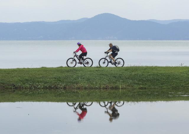 (260719) -- KUNMING, July 19, 2026 (Xinhua) -- Tourists ride bicycles at a wetland park in Kunming City, southwest China's Yunnan Province, July 19, 2026. (Photo by Zheng Yi/Xinhua)