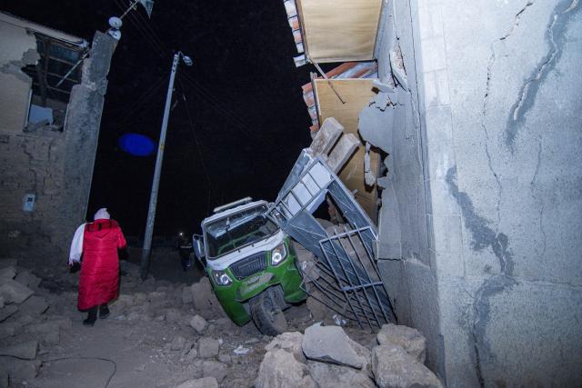 (260720) -- CHUPACA, July 20, 2026 (Xinhua) -- A resident walks past damaged houses after an earthquake in Chupaca province, Junin, Peru, July 18, 2026. At least five people were killed after an earthquake struck Peru's central department of Junin Saturday night, local media reported Sunday. (Xinhua)