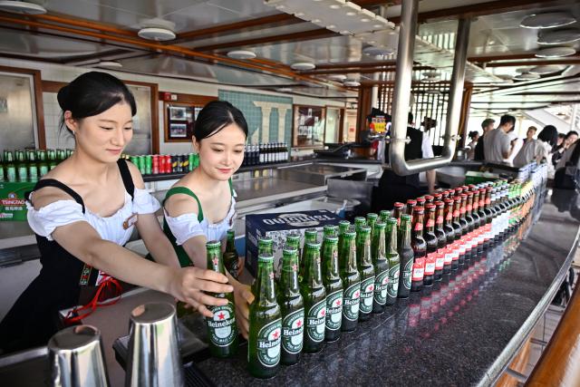 (260720) -- QINGDAO, July 20, 2026 (Xinhua) -- Staff members prepare beer for visitors aboard cruise ship Dream at Qingdao International Cruise Terminal in Qingdao, east China's Shandong Province, July 20, 2026. As a part of the 36th Qingdao International Beer Festival, a cruise tour event kicked off at the Qingdao International Cruise Terminal on Monday. Featuring live performances and interactive experiences, this event created an immersive maritime leisure space for visitors. (Xinhua/Li Ziheng)