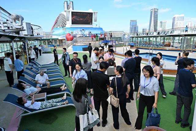 (260720) -- QINGDAO, July 20, 2026 (Xinhua) -- People take part in a cruise tour event aboard cruise ship Dream at Qingdao International Cruise Terminal in Qingdao, east China's Shandong Province, July 20, 2026. As a part of the 36th Qingdao International Beer Festival, a cruise tour event kicked off at the Qingdao International Cruise Terminal on Monday. Featuring live performances and interactive experiences, this event created an immersive maritime leisure space for visitors. (Xinhua/Li Ziheng)