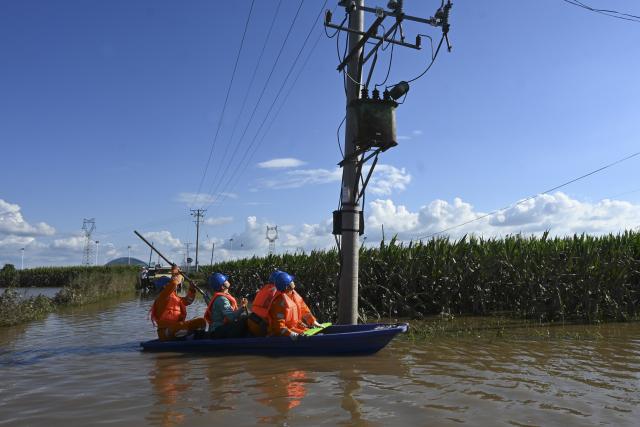 (260720) -- MUDANJIANG, July 20, 2026 (Xinhua) -- Staff members inspect power lines for electricity restoration in Ning'an Township of Ning'an City, Mudanjiang, northeast China's Heilongjiang Province, July 20, 2026. Water supply and power departments in Mudanjiang have stepped up efforts to restore water and electricity services in the affected areas as flooding gradually recedes in the city. (Photo by Zhang Chunxiang/Xinhua)