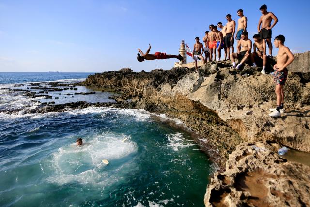 (260721) -- BEIJING, July 21, 2026 (Xinhua) -- People dive into the sea on Zireh Island off the coast of Sidon, Lebanon, as the country experiences a heat wave, on July 19, 2026. (Photo by Ali Hashisho/Xinhua)