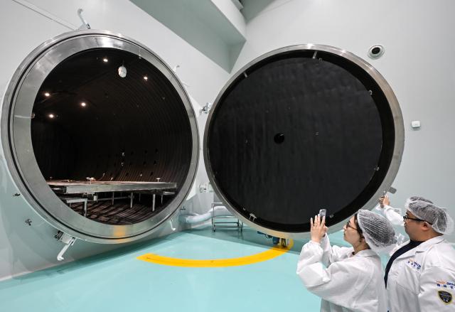 (260721) -- WUXI, July 21, 2026 (Xinhua) -- Journalists take photos of a thermal vacuum simulator at Guoyu Starry Sky Technology Co., Ltd. in the high-tech zone of Wuxi, east China's Jiangsu Province, July 20, 2026. Guoyu Starry Sky Technology Co., Ltd. specializes in the design and manufacturing of satellites. Its intelligent production line for commercial satellites can produce more than 150 units annually, each weighing between 200 kg and 500 kg. (Xinhua/Chen Yehua)