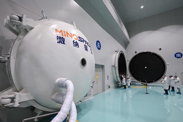 (260721) -- WUXI, July 21, 2026 (Xinhua) -- Journalists take photos of a thermal vacuum simulator at Guoyu Starry Sky Technology Co., Ltd. in the high-tech zone of Wuxi, east China's Jiangsu Province, July 20, 2026. Guoyu Starry Sky Technology Co., Ltd. specializes in the design and manufacturing of satellites. Its intelligent production line for commercial satellites can produce more than 150 units annually, each weighing between 200 kg and 500 kg. (Xinhua/Chen Yehua)