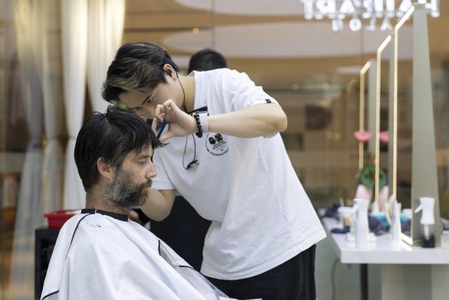 (260721) -- SHANGHAI, July 21, 2026 (Xinhua) -- A foreign tourist gets a haircut at a barber shop in east China's Shanghai, June 13, 2026. (Xinhua/Wang Xiang)