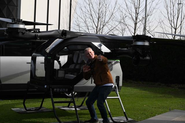 (260721) -- MELBOURNE, July 21, 2026 (Xinhua) -- A visitor shoots a video of XPENG's modular flying car, known as the Land Aircraft Carrier, at an event held in Melbourne, Australia, on July 21, 2026.
  Chinese new-energy vehicle maker XPENG on Tuesday unveiled its development plan for the Australian market as part of its broader strategy for Australia and New Zealand, with its seven-seat flagship X9 making its Australian debut and the right-hand-drive version of the L03 compact SUV also on display.
  TO GO WITH "XPENG expands presence in Australia with new models, stronger after-sales network" (Xinhua/Xu Haijing)