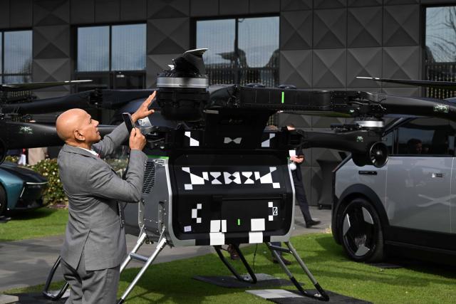 (260721) -- MELBOURNE, July 21, 2026 (Xinhua) -- A visitor takes photos of XPENG's modular flying car, known as the Land Aircraft Carrier, at an event held in Melbourne, Australia, on July 21, 2026.
  Chinese new-energy vehicle maker XPENG on Tuesday unveiled its development plan for the Australian market as part of its broader strategy for Australia and New Zealand, with its seven-seat flagship X9 making its Australian debut and the right-hand-drive version of the L03 compact SUV also on display.
  TO GO WITH "XPENG expands presence in Australia with new models, stronger after-sales network" (Xinhua/Xu Haijing)