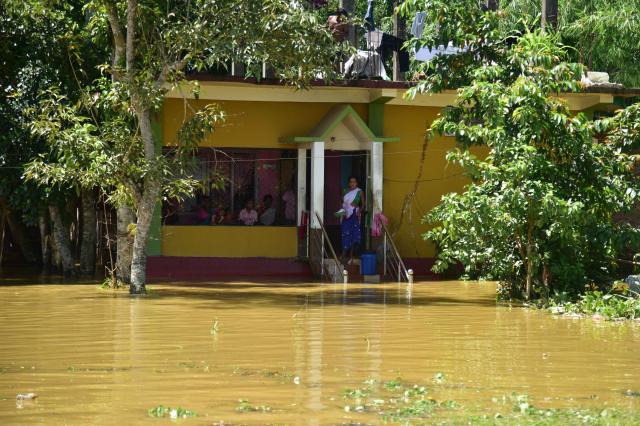 (260721) -- NEW DELHI, July 21, 2026 (Xinhua) -- Villagers stay at a house besieged by floodwaters after heavy rains in Jorhat district of India's northeastern state of Assam, on July 21, 2026. (Str/Xinhua)