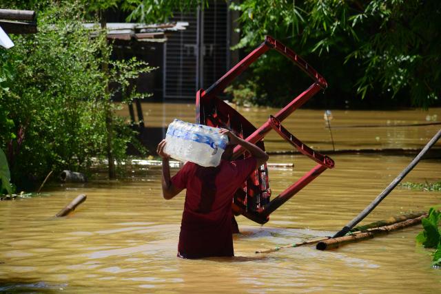 (260721) -- NEW DELHI, July 21, 2026 (Xinhua) -- A villager wades through floodwaters after heavy rains in Jorhat district of India's northeastern state of Assam, on July 21, 2026. (Str/Xinhua)