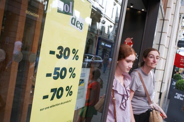 (260721) -- PARIS, July 21, 2026 (Xinhua) -- People walk past sale advertisements of a shop in Paris, France, on July 21, 2026. France's 2026 summer sales had been extended by one week to July 28 after a heatwave kept customers away from stores. (Xinhua/Wu Huiwo)