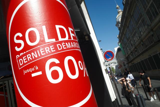(260721) -- PARIS, July 21, 2026 (Xinhua) -- People walk past sale advertisements of a shop in Paris, France, on July 21, 2026. France's 2026 summer sales had been extended by one week to July 28 after a heatwave kept customers away from stores. (Xinhua/Wu Huiwo)