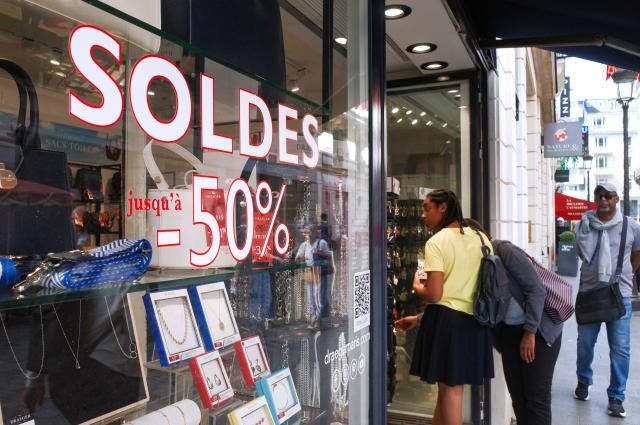 (260721) -- PARIS, July 21, 2026 (Xinhua) -- People walk past sale advertisements of a shop in Paris, France, on July 21, 2026. France's 2026 summer sales had been extended by one week to July 28 after a heatwave kept customers away from stores. (Xinhua/Wu Huiwo)