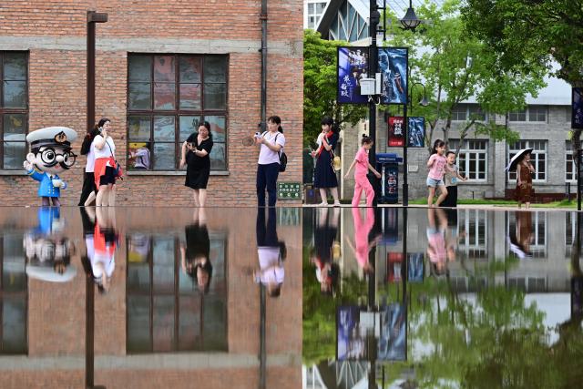 (260722) -- BEIJING, July 22, 2026 (Xinhua) -- Tourists visit the China Shipyard Culture Park in Fuzhou, southeast China's Fujian Province, July 18, 2026. The China Shipyard Culture Park, opened in 2023 on the site of a century-old shipbuilding complex, preserves a collection of historic industrial buildings. The park combines exhibitions, educational programs, performances and tourism, showcasing China's modern shipbuilding heritage. (Xinhua/Lin Shanchuan)