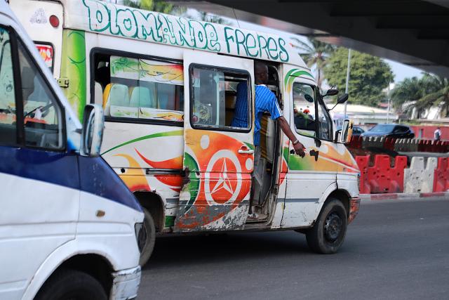 (260722) -- ABIDJAN, July 22, 2026 (Xinhua) -- A minibus conductor calls for passengers in Abidjan, Cote d'Ivoire, on July 21, 2026. Colorful minibuses serve as a primary mode of transport and a vibrant element of local street culture in Abidjan, the economic capital of Cote d'Ivoire. (Photo by Yvan Sonh/Xinhua)